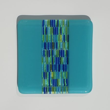 A pair of fused glass tapestry stripe coaster with turquoise edging