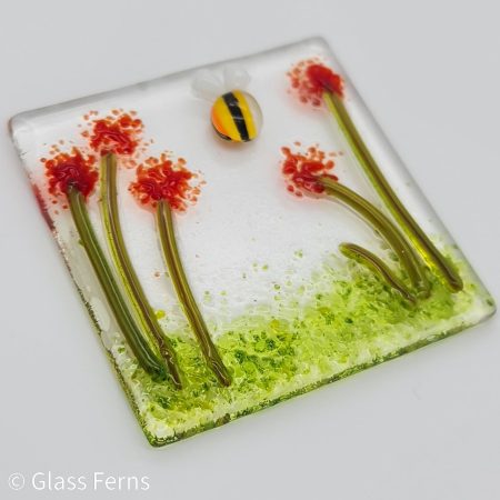 Keepsake fused glass blank card featuring a little buzzing bee in amongst bright red pom-pom flowers