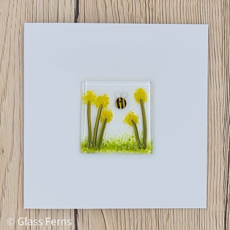 Keepsake fused glass blank card featuring a little bee buzzing in amongst the yellow pom-pom flowers