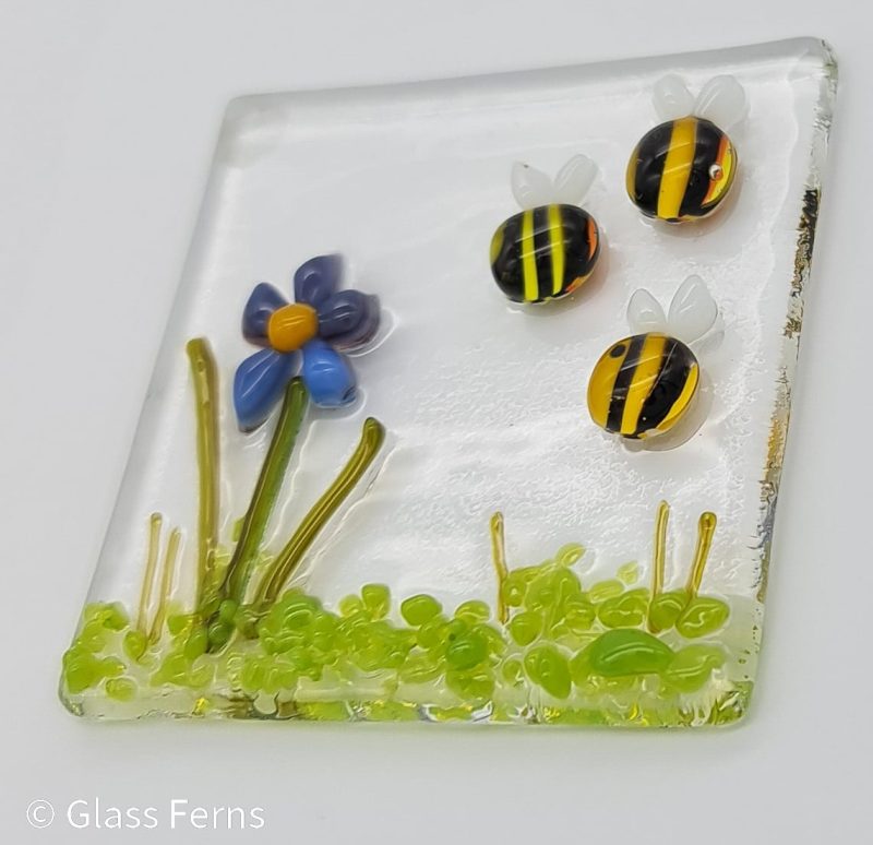 Keepsake fused glass blank card featuring a trio of bees buzzing by a cute purple and blue flower