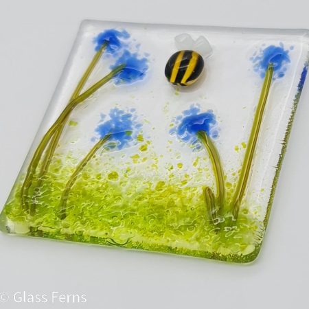 Keepsake fused glass blank card featuring a little bee buzzing in amongst blue pom-pom flowers