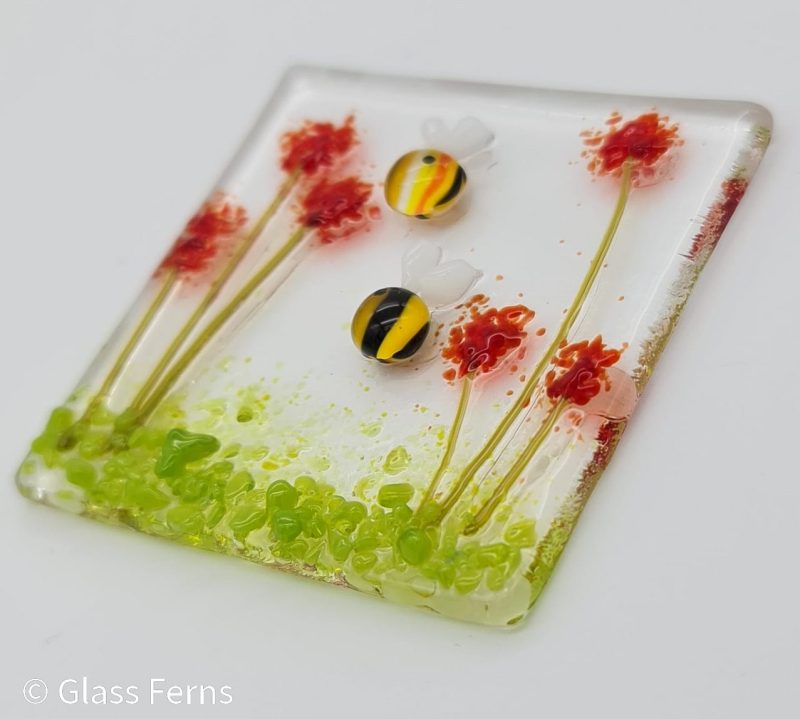 Keepsake fused glass blank card featuring two cute bees in amongst bright red pom-pom flowers