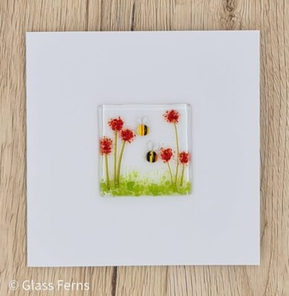 Keepsake fused glass blank card featuring two cute bees in amongst bright red pom-pom flowers