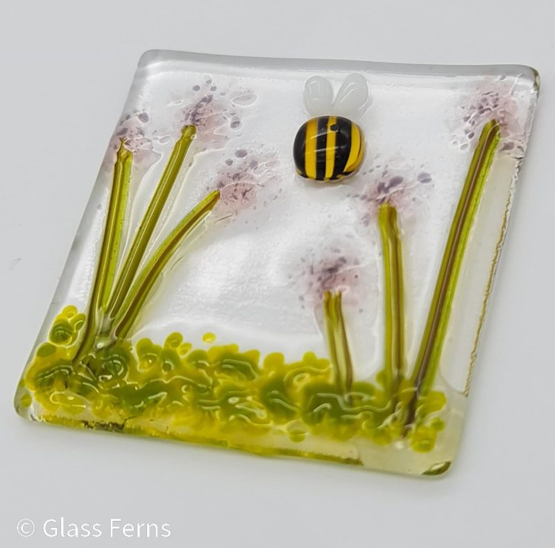 Keepsake fused glass blank card featuring a little bee buzzing in amongst pale lilac pom-pom flowers