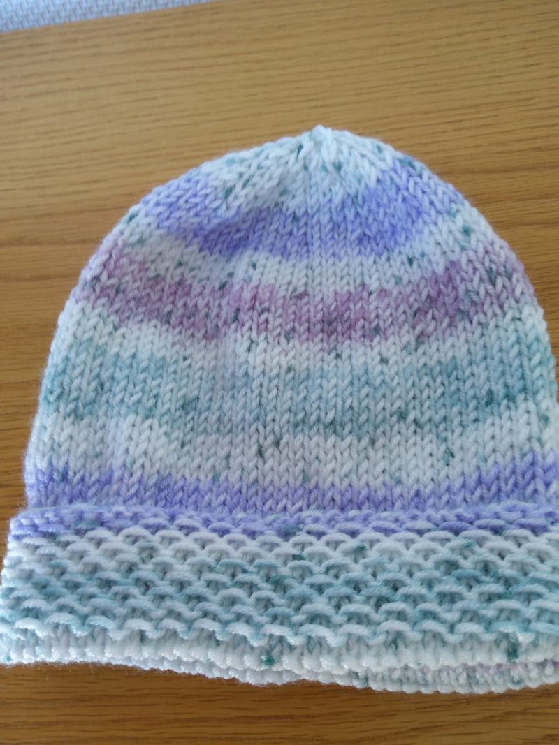 A lovely hand-knitted and hat age 0-6 months in a soft self-stripping yarn