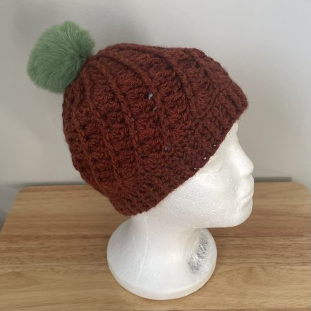 Hand-made crochet hat, brown with a green faux fur bobble