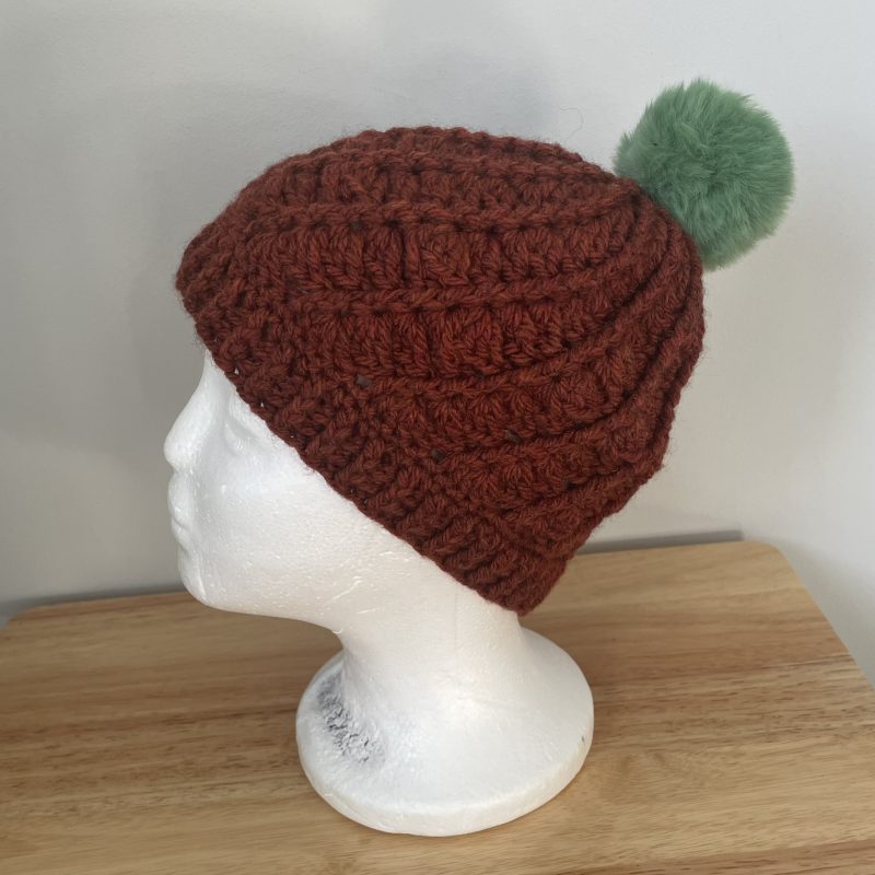 Hand-made crochet hat, brown with a green faux fur bobble