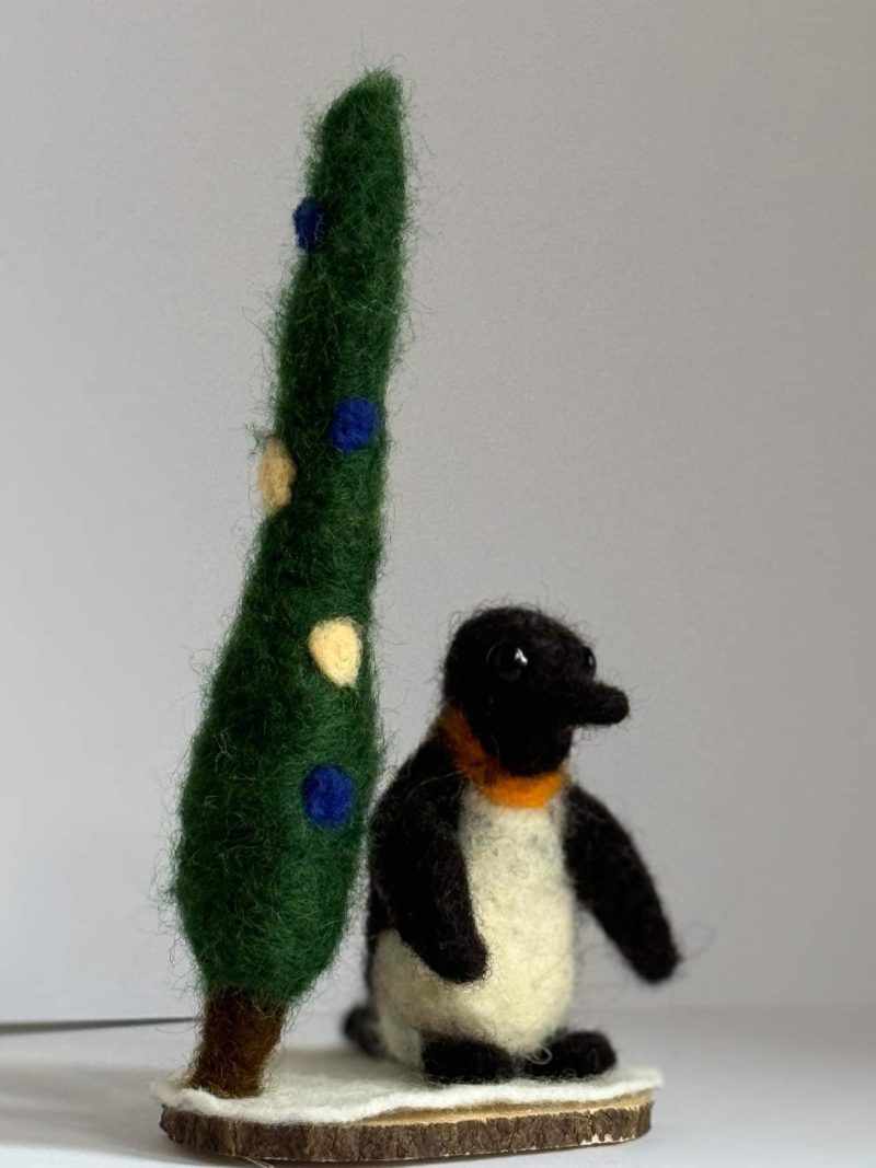 Needle felted Igloo the penguin by a pine tree 🌲