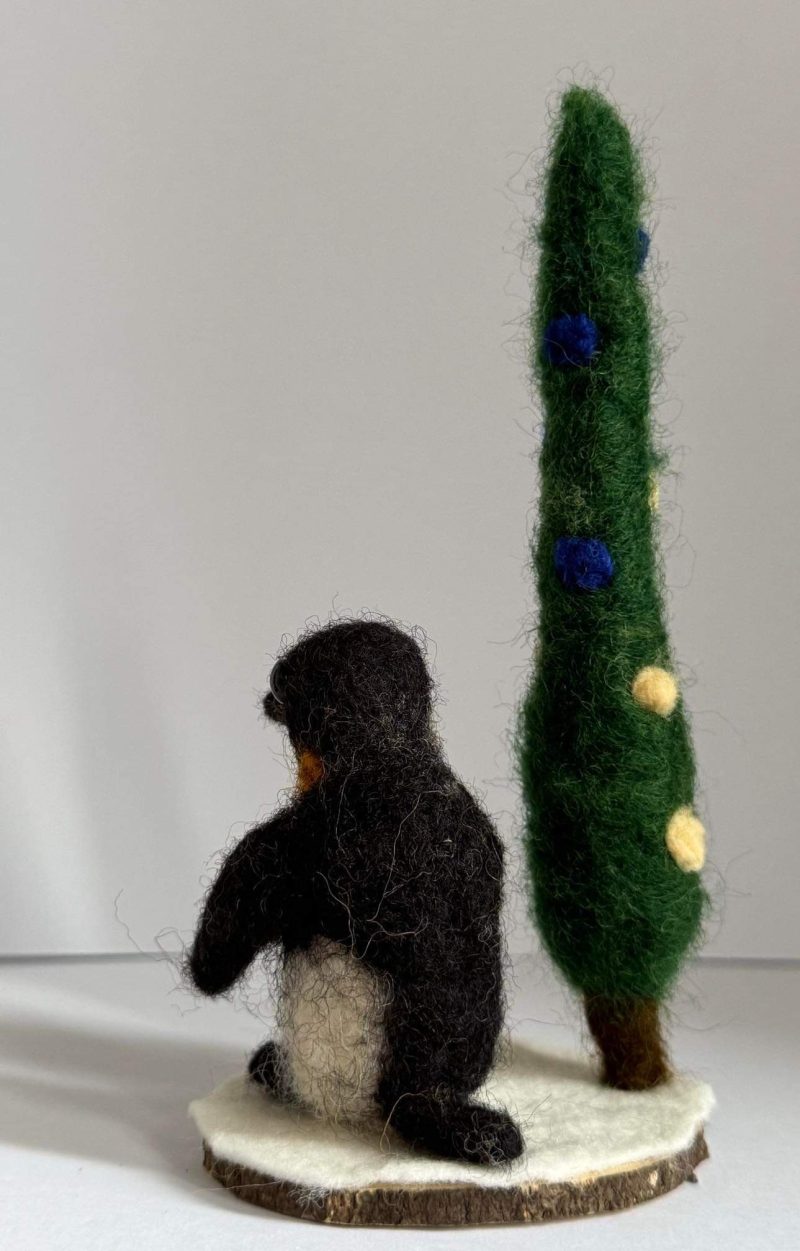 Needle felted Igloo the penguin by a pine tree 🌲