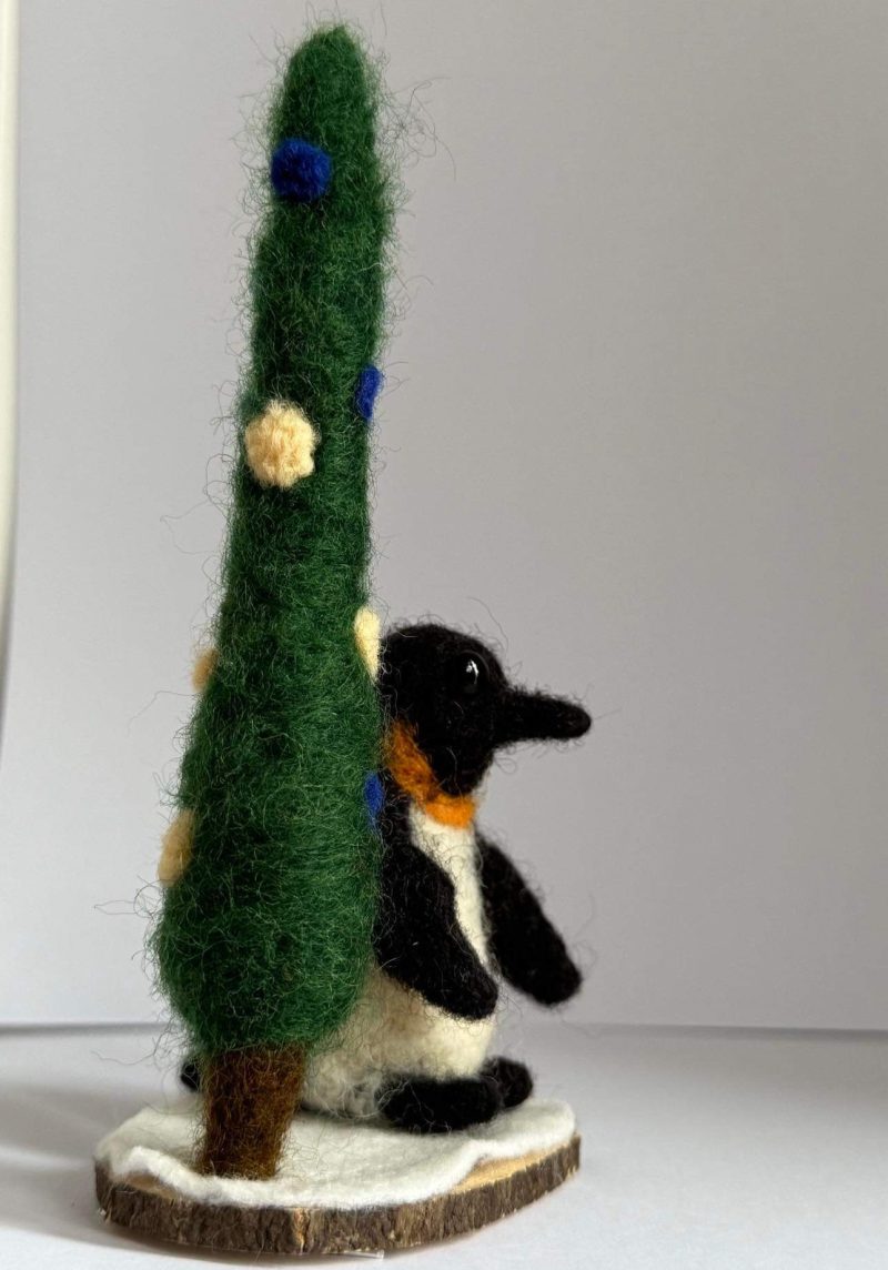 Needle felted Igloo the penguin by a pine tree 🌲