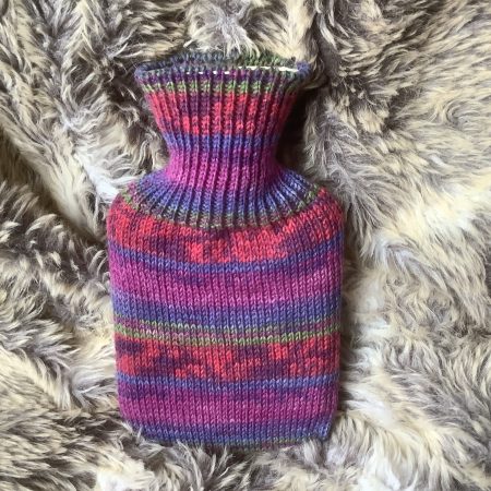 Pocket size dinky hot water bottle with hand crafted cover ( yarn design George)