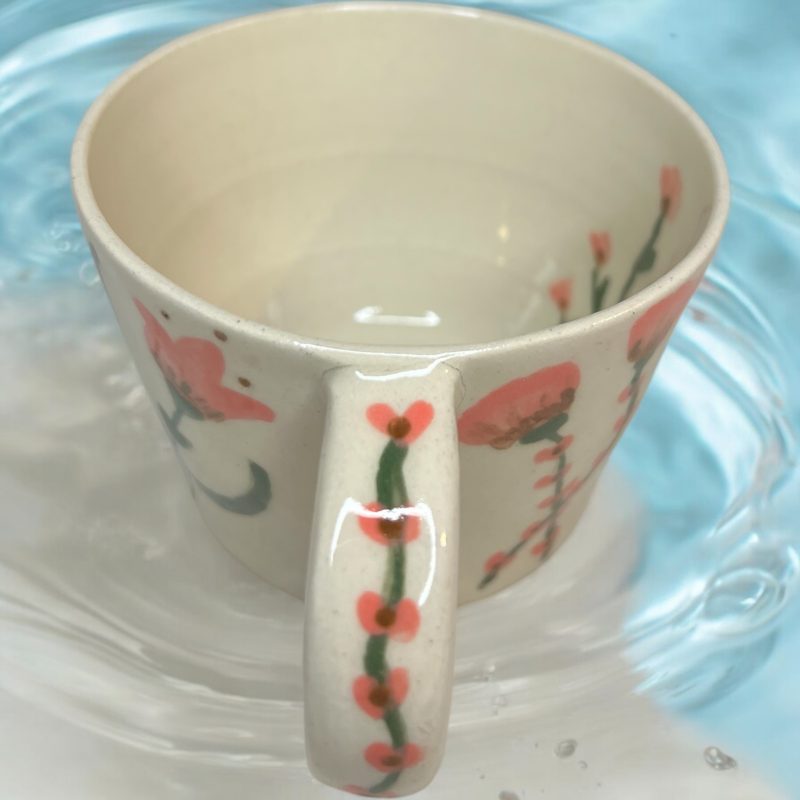 Handthrown mug with hand drawn floral design