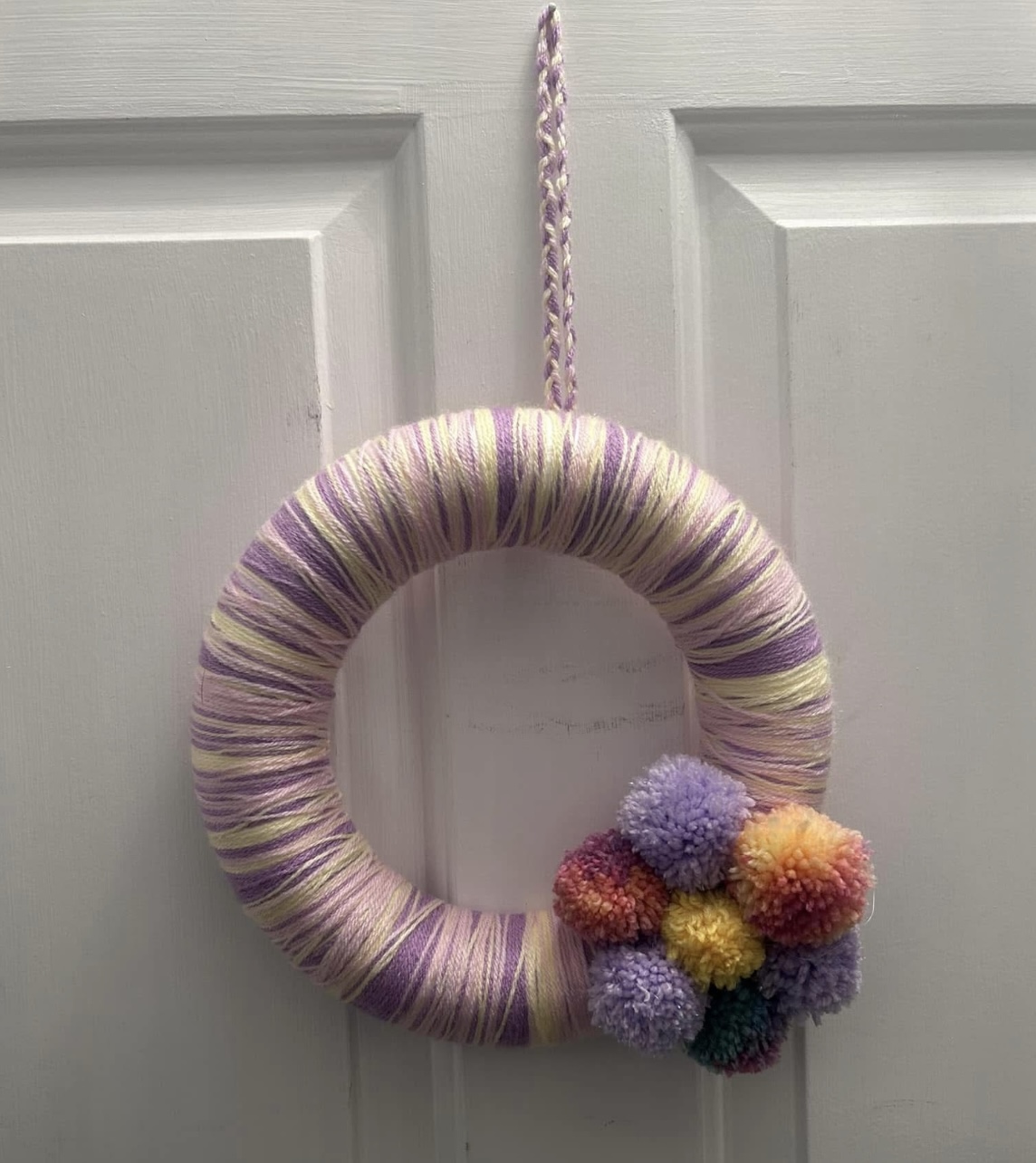 Handmade lilac, lemon and pink wool wrapped wreath with pompom flower