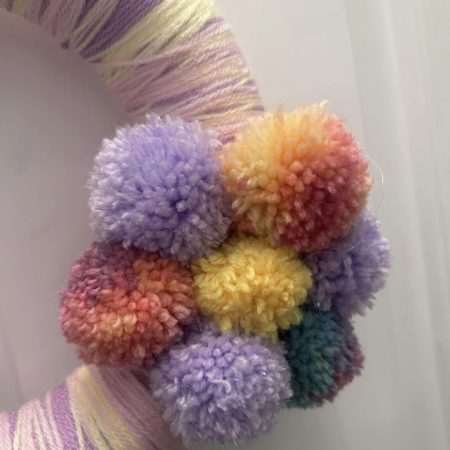 Handmade lilac, lemon and pink wool wrapped wreath with pompom flower