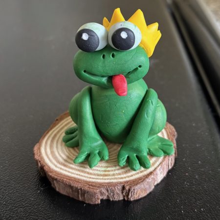 Handmade Clay Green frog sitting on a Wooden Slice
