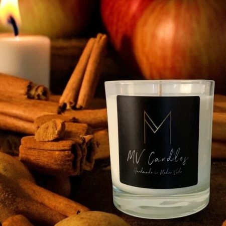 Cinnamon and apple scented candle in a clear glass container