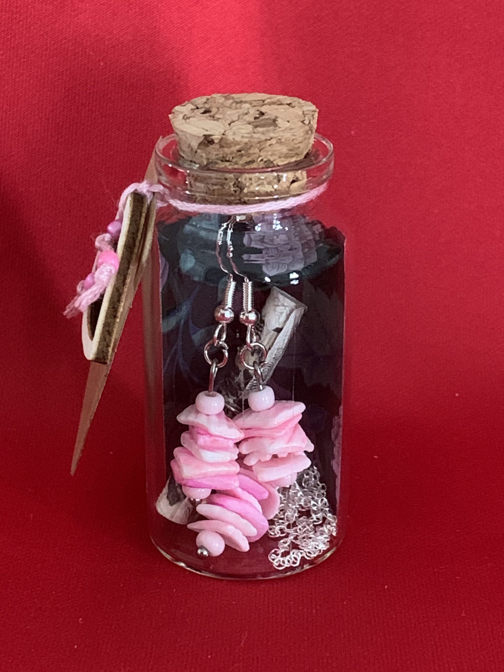 Sterling silver earrings and necklace set with pink shells inside a message in a bottle