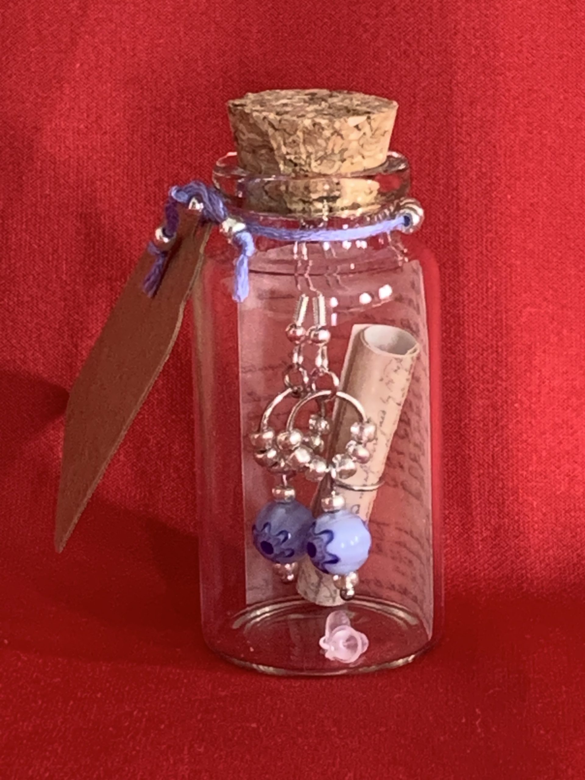 Lovely handmade sterling silver earrings with floral blue glass beads in a bottle with scroll