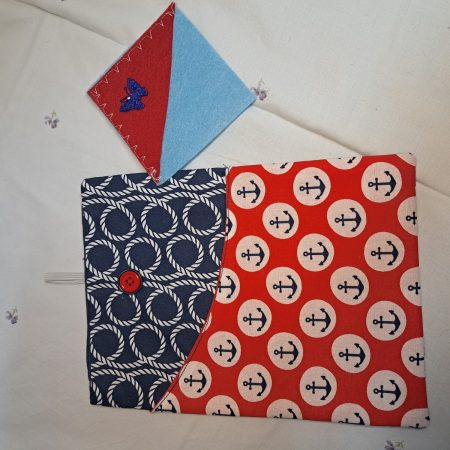 Book holder with pocket at the front and a fabric corner bookmark