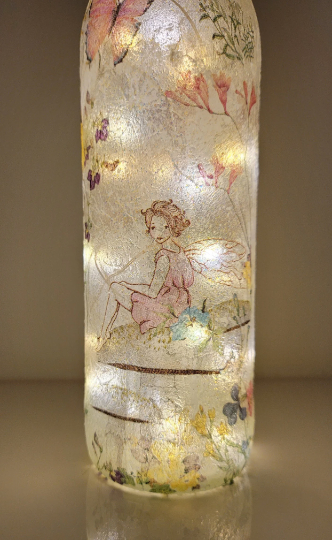 Lit up standard wine bottle with Fairy and flower butterfly detailing. Cork LED lights