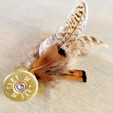 Brooch made from a recycled shotgun cartridge end and brown pheasant feathers