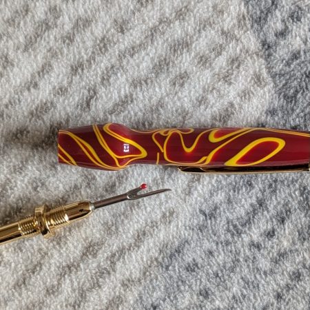 Seam ripper-unpicker made from red and yellow acrylic with gold coloured fittings