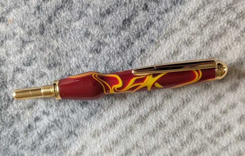 Seam ripper-unpicker made from red and yellow acrylic with gold coloured fittings