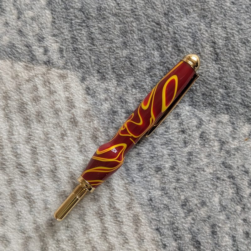 Seam ripper-unpicker made from red and yellow acrylic with gold coloured fittings