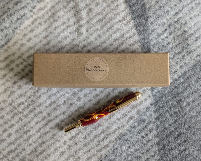 Seam ripper-unpicker made from red and yellow acrylic with gold coloured fittings