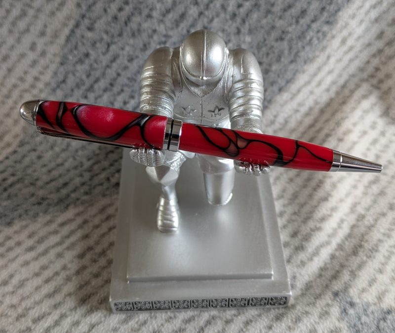 Euro twist ballpoint pen in red acrylic with black lines and swirls with shiny chrome fittings