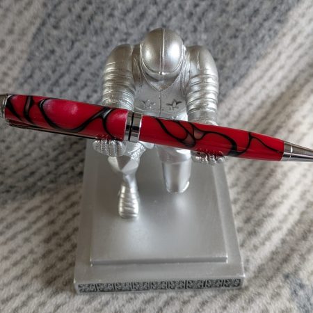 Euro twist ballpoint pen in red acrylic with black lines and swirls with shiny chrome fittings