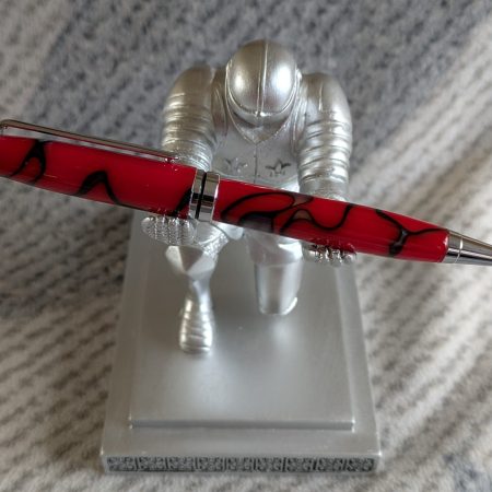 Euro twist ballpoint pen in red acrylic with black lines and swirls with shiny chrome fittings