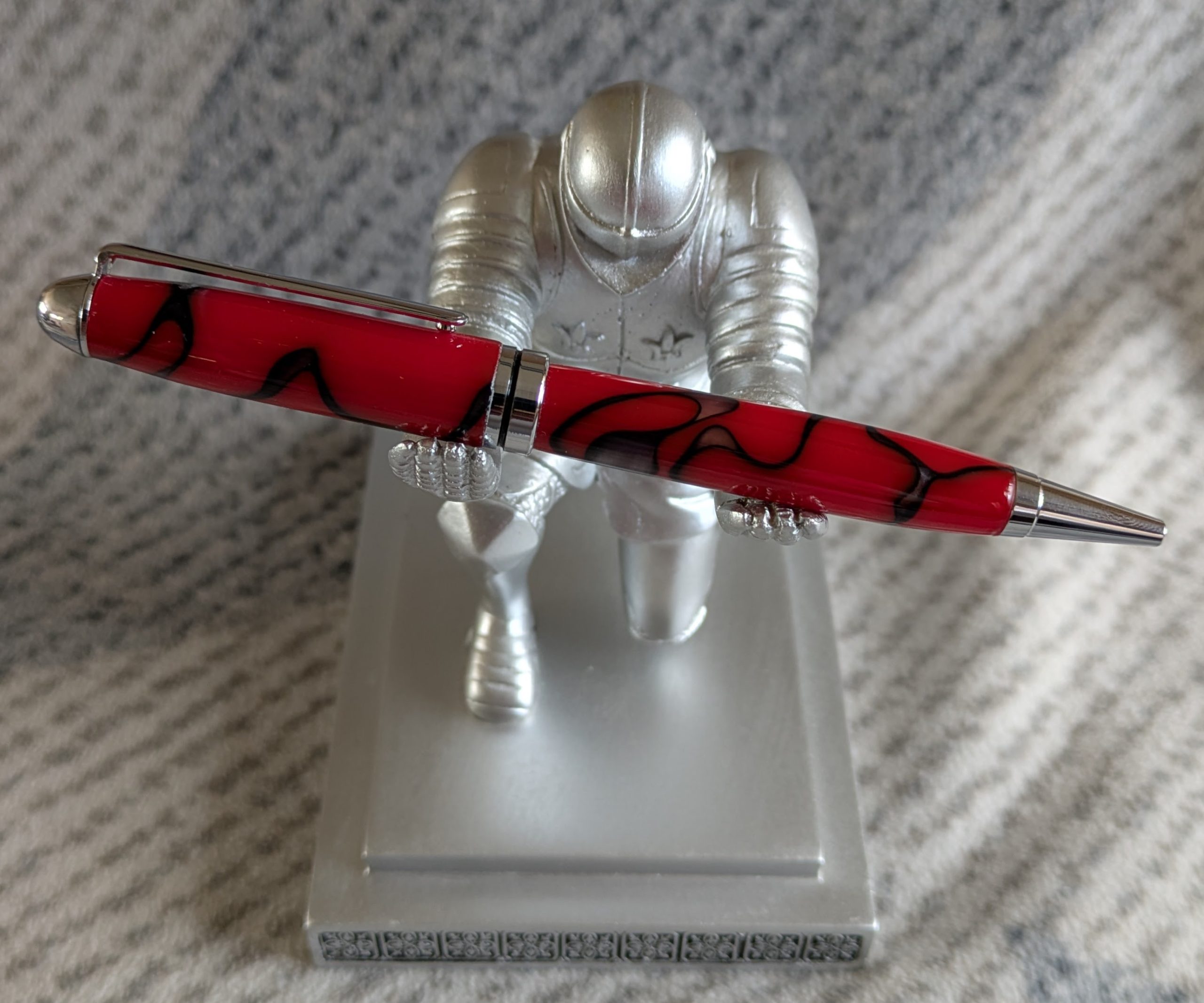 Euro twist ballpoint pen in red acrylic with black lines and swirls with shiny chrome fittings