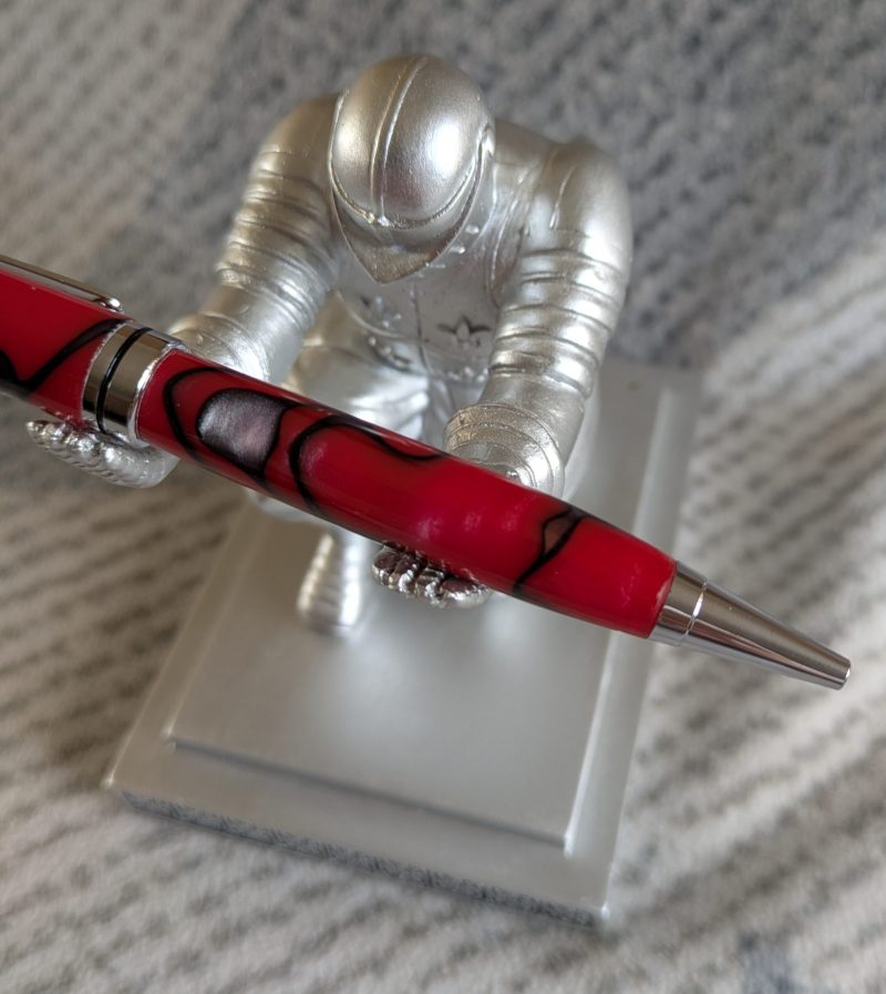 Euro twist ballpoint pen in red acrylic with black lines and swirls with shiny chrome fittings