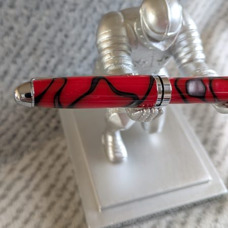 Euro twist ballpoint pen in red acrylic with black lines and swirls with shiny chrome fittings