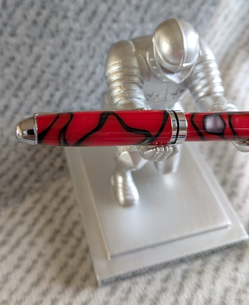 Euro twist ballpoint pen in red acrylic with black lines and swirls with shiny chrome fittings