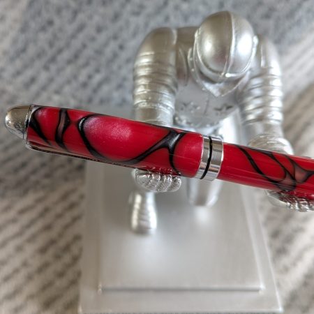 Euro twist ballpoint pen in red acrylic with black lines and swirls with shiny chrome fittings