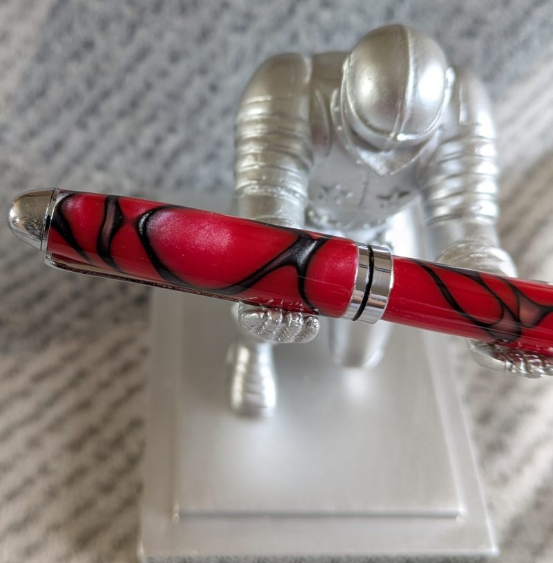 Euro twist ballpoint pen in red acrylic with black lines and swirls with shiny chrome fittings
