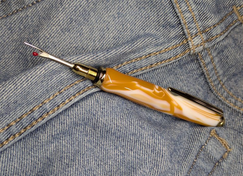 Seam ripper-unpicker made from caramel and cream coloured acrylic with shiny gold coloured fittings