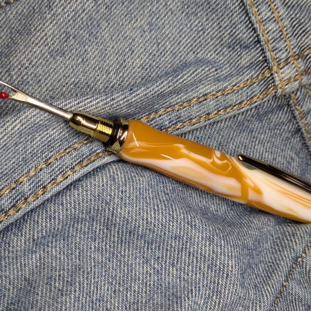 Seam ripper-unpicker made from caramel and cream coloured acrylic with shiny gold coloured fittings