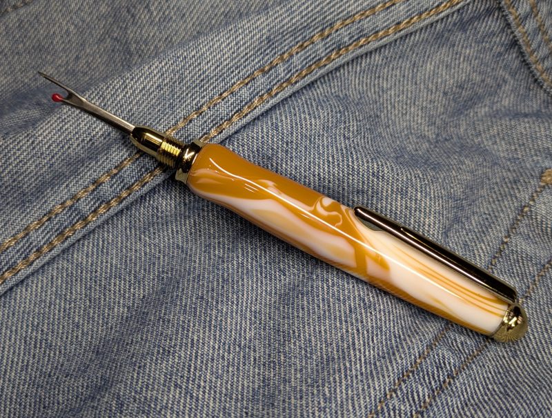 Seam ripper-unpicker made from caramel and cream coloured acrylic with shiny gold coloured fittings