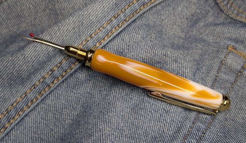 Seam ripper-unpicker made from caramel and cream coloured acrylic with shiny gold coloured fittings