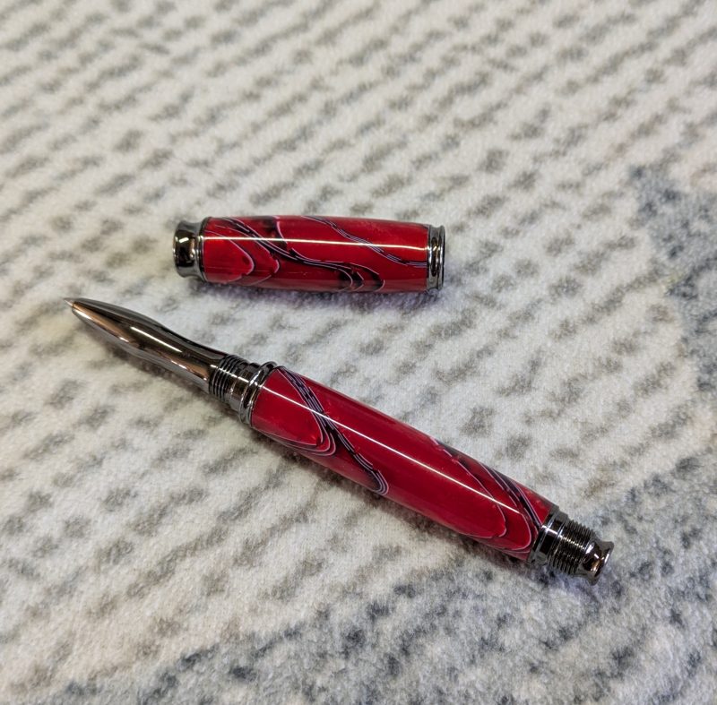 Acrylic omega style Rollerball Pen Made from red acrylic; with black and white lines