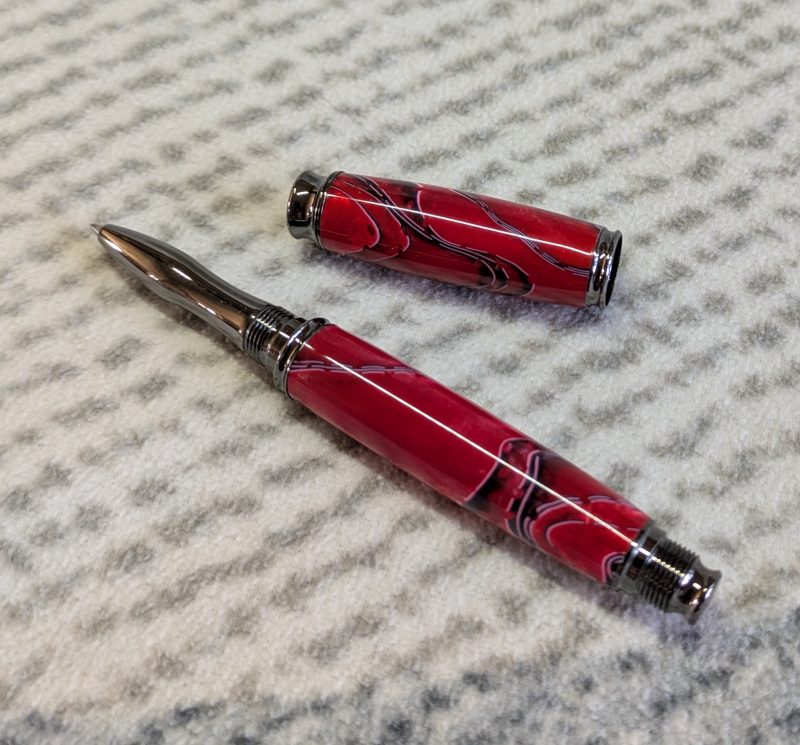 Acrylic omega style Rollerball Pen Made from red acrylic; with black and white lines