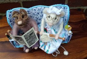 needle felted couple relaxing on a hand made settee