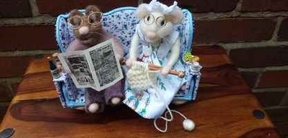needle felted couple relaxing on a hand made settee