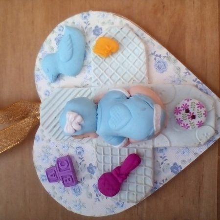 wooden plaque with clay baby figures