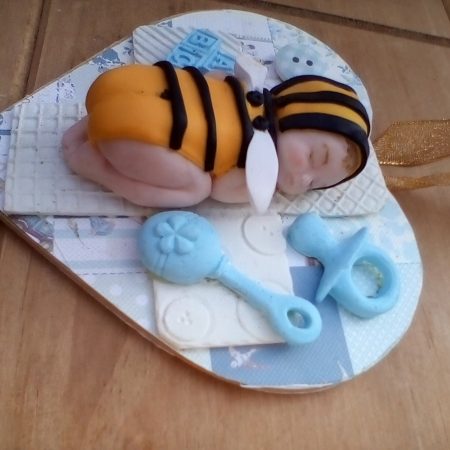wooden plaque with clay bee baby figure