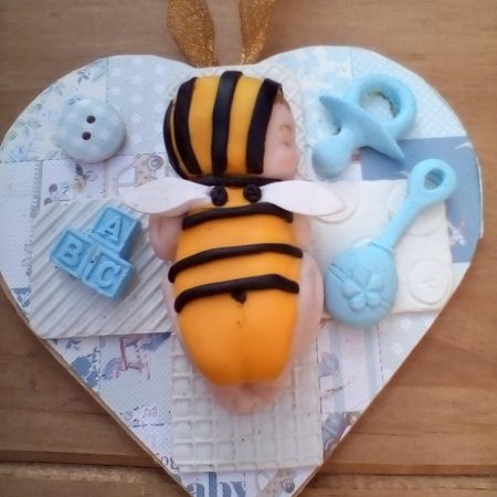 wooden plaque with clay bee baby figure