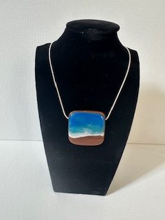 Hand made ocean wave pendant on wood